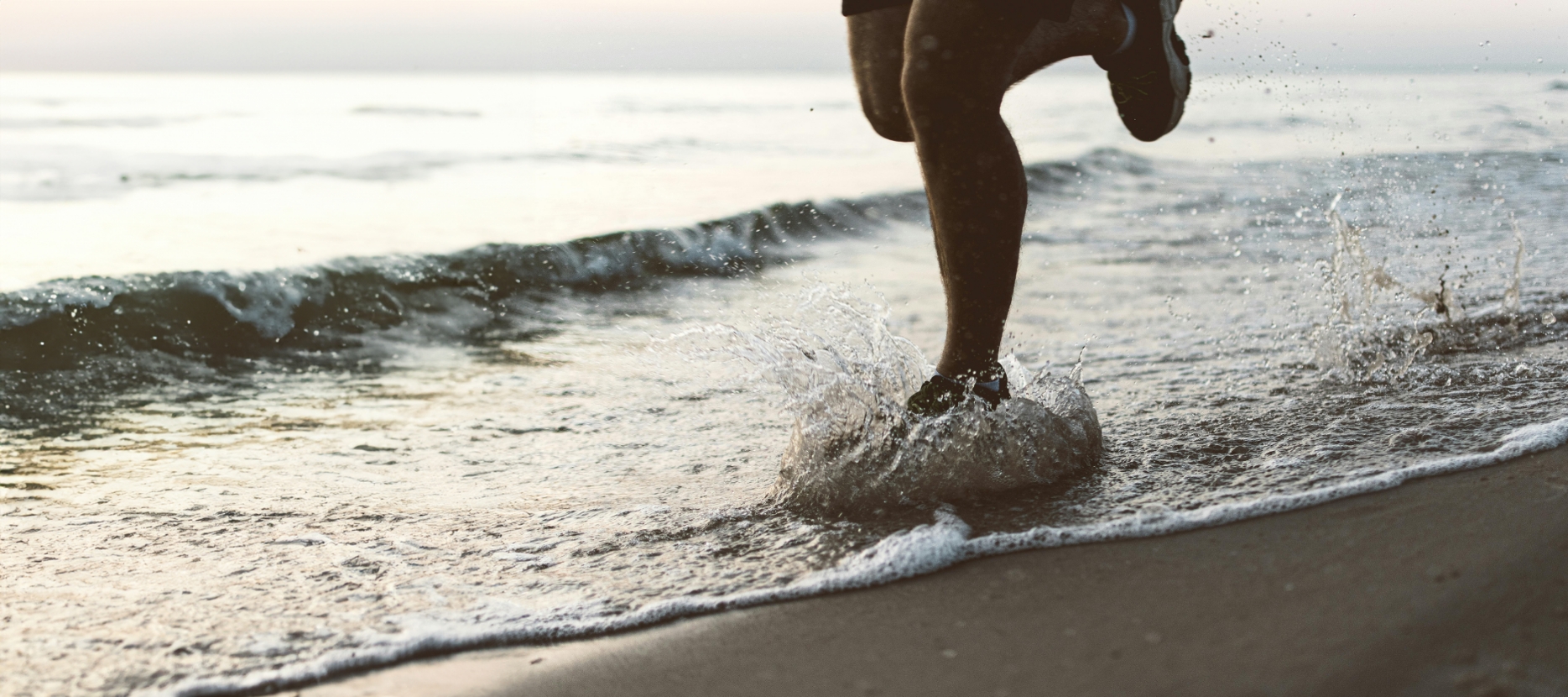 Beine einer Person die im Wasser rennt